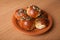 Freshly baked rolls lying in the ceramic dish on wooden table