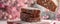 Freshly Baked Sliced Artisan Bread Falling onto Wooden Board with Flour Dusting and Pink Blossom Background