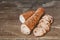 Freshly Baked Sliced Integral Baguette Bread Elongated Loaf Set On Old Weathered Cracked Flaky Picnic Table Grunge Surface