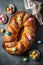 Freshly baked sweet braided Easter bread decorated with colorful chocolate eggs on wooden board top down view. AI generated