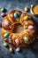 Freshly baked sweet Easter bread decorated with colorful chocolate eggs on wooden board top down view. Traditional holiday pastry