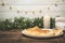 Freshly baked tasty homemade pie on a white plate. A large candle and New Year`s lights are lit.