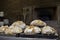 Freshly baked traditional breads with in background a classical oven for baking. Food icon, work place.