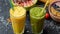 Freshly blended fruit smoothies in glasses. Yellow, green drinks