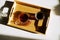 Freshly brewed black filter coffee is served on a bamboo tray on sunlit white table. Top view