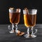 Freshly brewed black tea with cinnamon, in transparent cups on a dark background