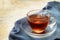 Freshly brewed black tea in a glass cup, steaming hot drink on a