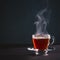 Freshly brewed black tea in a transparent glass Cup,escaping steam