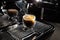 Freshly brewed creamy espresso in a transparent coffee cup placed on a manual coffee machine, close up