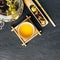 Freshly brewed Herbal tea. Wooden spoon. Glass jar with tea leaves.Dark concrete stone background