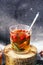 Freshly brewed tea in glass cup on blue background. Orange hot drink, selective focus. Fresh herbal tea with tincture of red berri