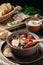 Freshly cooked borscht - traditional dish of Russian and Ukrainian cuisine in earthenware dish with bacon, sour cream