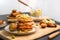 Freshly-cooked meatloaf burger served on a rustic wooden table surrounded by condiments