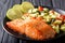 Freshly cooked salmon steak with lime, avocado and tomatoes close-up. horizontal