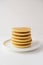 Freshly cooked soft delicious gluten free pancakes stacked on white plate.