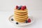 Freshly cooked soft delicious gluten free pancakes stacked on white plate