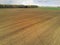 Freshly cultivated farmland with animal trails, Forest in the background, Cloudy blue sky, Concept agriculture