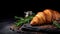 Freshly Cut Croissant With Rosemary On Dark Stone Background