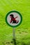 Freshly cut green grass with round sign forbidding dogs