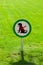 Freshly cut green grass with round sign forbidding dogs