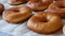 Freshly fried large round donuts on the table in the home kitchen. Donuts without glaze and powder