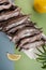 Freshly frozen capelin lies on a white plate on a light blue-green background..