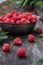 Freshly harvested raspberry. Raspberries on wooden background close up, metal cup with raspberries in the background.