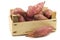 Freshly harvested sweet potatoes in a wooden crate