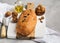 Freshly healthy bread with walnuts and raisins on cutting board on gray stone background.