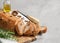 Freshly healthy Sliced bread with walnuts and raisins on cutting board on gray stone background.