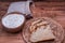 Freshly homemade bread and flour in bowl and wheat grains in bag on wooden table