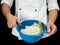 Freshly made boiled parted cabbage in a colander, held by chef i