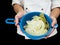 Freshly made boiled parted cabbage in a colander, held by chef i