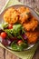 Freshly made crispy fritters from sweet potato and fresh vegetable salad close-up. Vertical top view