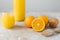 Freshly made orange juice containing vitamin C, sliced oranges, wooden cork and squeezer. Process of making fruit drink. Healthy