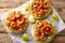 Freshly made shrimp tostadas topped with guacamole, onion, tomatoes, and cucumbers closeup on the table. Horizontal top view