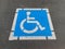 Freshly painted blue and white handicapped disabled parking sign on asphalt lot