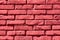 Freshly painted dark red to cherry color cracked damaged bricks texture on local train station building wall
