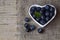 Freshly picked organic blueberries in a white heart shaped bowl on wooden background.Blueberry.Bilberries.