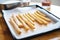 freshly piped churro dough on a tray before frying