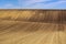 freshly ploughed brown farm field. undulating hilly rural land. abstract perspective view