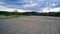 Freshly plowed field with rich, dark soil stretching out before a majestic forest backdrop