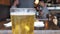 Freshly poured glass of light lager beer bubbling at top of glass at a restaurant with people dining