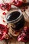 Freshly prepared delicious thick pomegranate sauce in a jar closeup. vertical