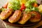 Freshly prepared potato pancakes are served with fresh salad close-up. horizontal