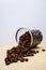 Freshly roasted coffee beans poured out of a glass jar. The floor is laid out on a white and wooden BACKGROUND