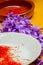 Freshly rolled strand saffron on white plate and background of purple saffron rose