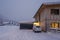 Freshly snow cleared entrance in the dead of winter with a car in front of wooden house garage