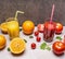 Freshly squeezed orange juice, sliced oranges, tomato juice with diced tomatoes wooden rustic background top view close up