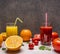 Freshly squeezed orange juice, sliced oranges, tomato juice with diced tomatoes on wooden rustic background top view close up